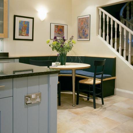 sarokbankett ülőhelyek a modern konyhában, halványkék egységgel és lépcsővel a felső emeletre