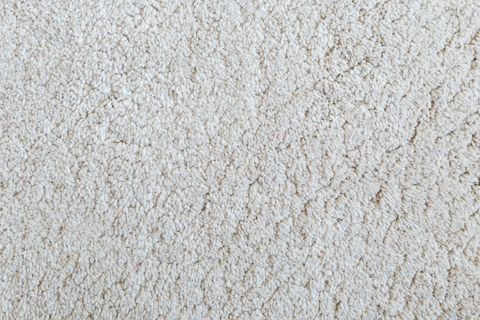 Vértes fehér bozontos szőnyeg textúra háttér felülről.