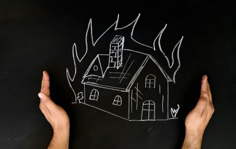 Lakásbiztosítási koncepció ember ház védelme a kezét a tűz