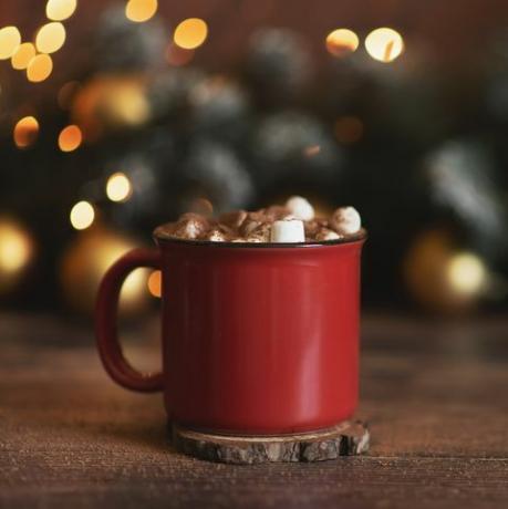 téli tejszínhab forró kávé egy piros bögre marshmallows vidéki csendélet karácsonyi képeslap