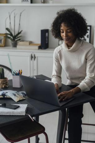 nő dolgozik az otthoni irodájában használ egy laptop