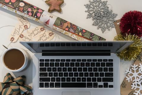 Laptop, kávé, csomagolópapír és karácsonyi díszek