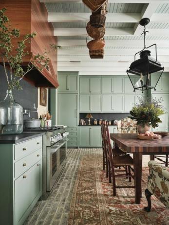konyha, zöld szekrények, területi szőnyeg, fából készült étkezőasztal fa székekkel, fából készült páraelszívó, zöld